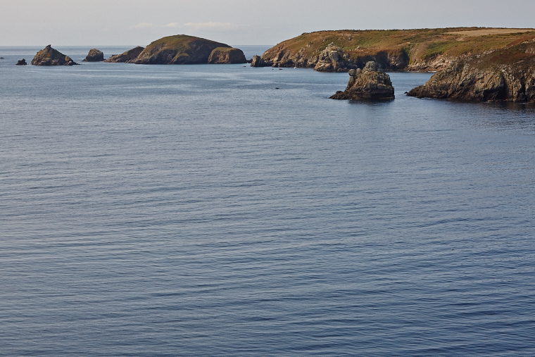 Calme rare aux confins de l’île — la mer se fait miroir, effaçant le vent et le tumulte des vagues.