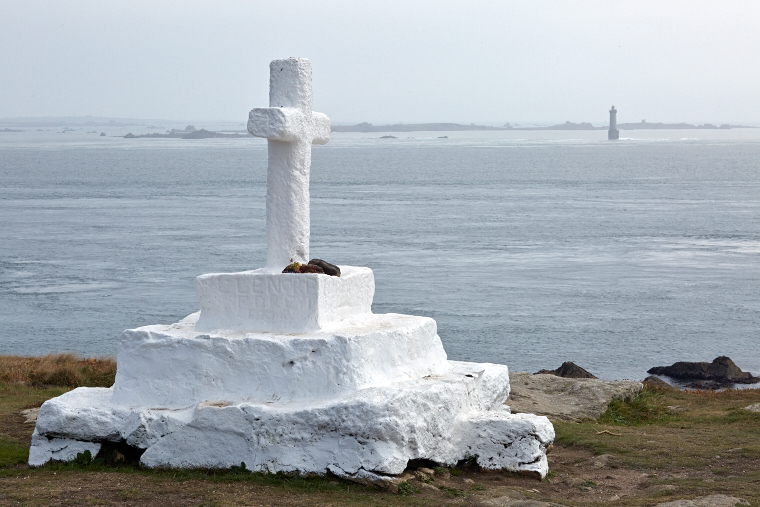Sur la falaise d’Ouessant, la croix de Pen-ar-Lan veille sur les marins disparus, face au phare du Créac’h qui se dresse dans la brume.