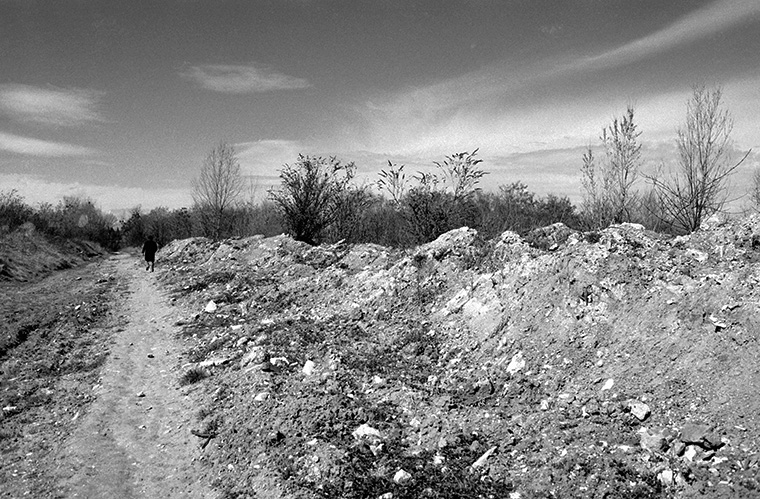 Au loin, un homme se déplace d&#039;un pas ferme sur un terrain vague, Rueil-Malmaison, avril 1987.