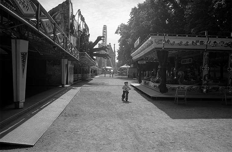 Un jeune enfant à vélo découvre la fête foraine des Tuileries, par un matin d’été à Paris, juillet 1987.